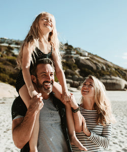 Mum and Dad with daughter at the beach.