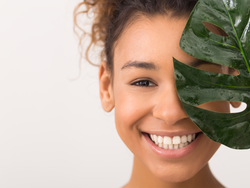 Young lady with nice skin holding up a leaf