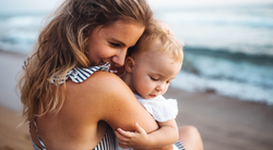 Mum hugging her baby in the sunlight