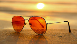 Sunglasses laid on beach sand